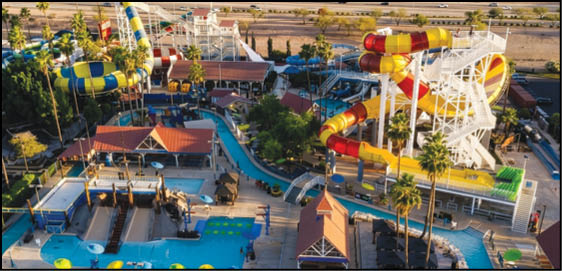 A vibrant water park with multiple colorful water slides, pools, a lazy river, and palm trees surrounded by pathways and seating areas. Description generated by AI