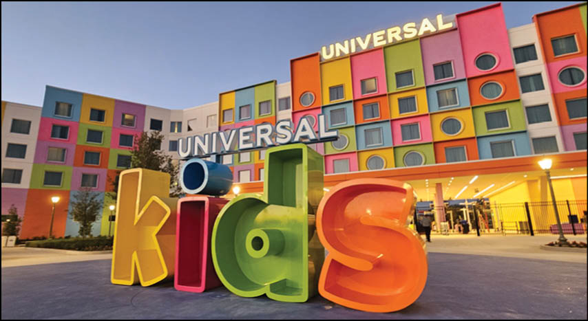 Large colorful letters spelling “kids" stand in front of a brightly painted building with the word "Universal" displayed on it. Description generated by AI