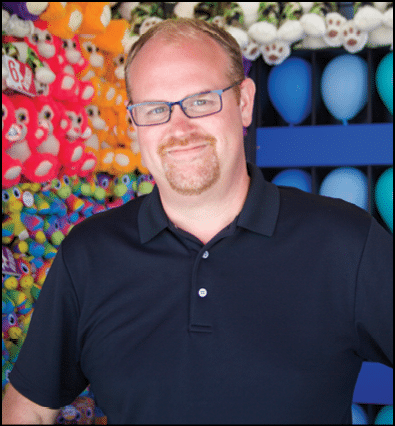 A man wearing glasses and a black shirt. Description generated by AI