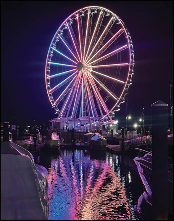 A large wheel with purple and pink lights on it. Description generated by AI