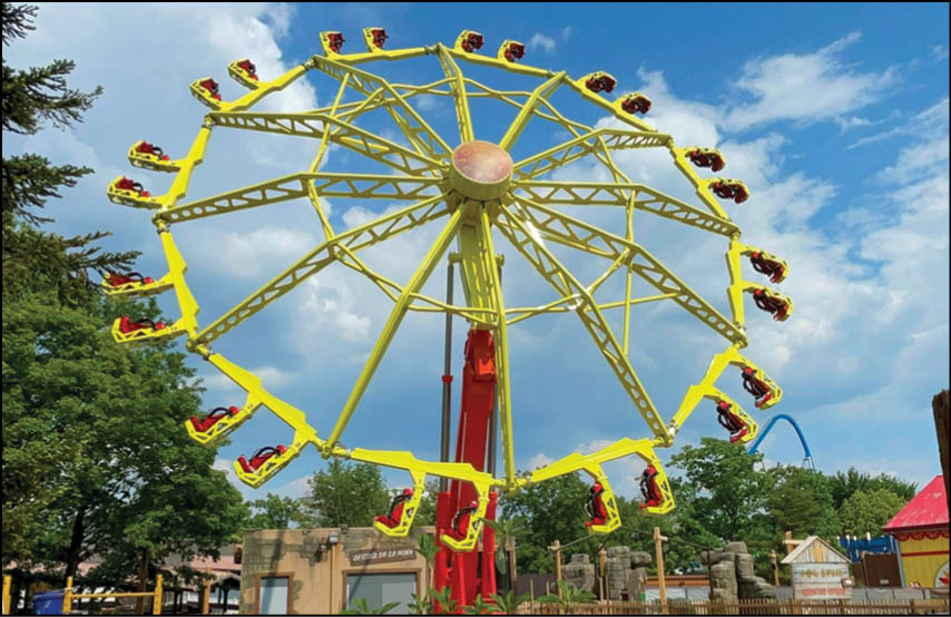 A yellow and red merry go round with a large wheel. Description generated by AI