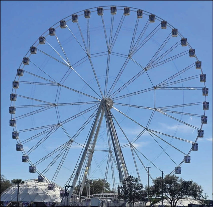 A large Ferris wheel with a blue sky in the background. Description generated by AI