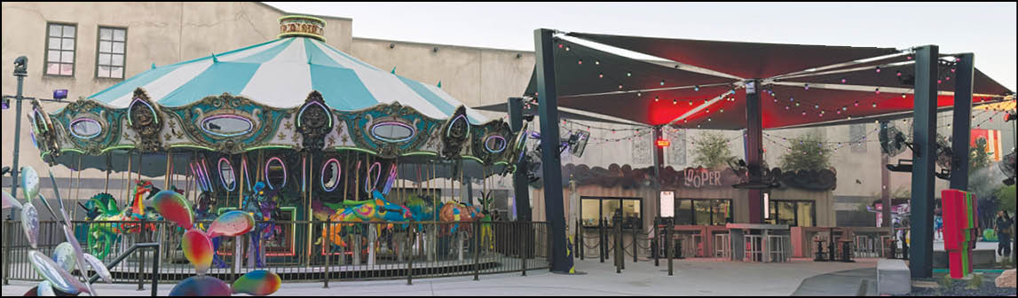 A carousel is in front of a building. Description generated by AI