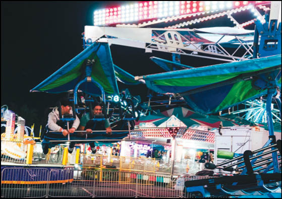 A carnival ride with a green and blue canopy. Description generated by AI