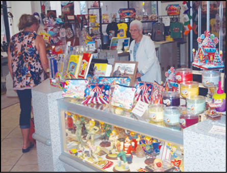 A woman standing in front of a display case with a variety of items. Description generated by AI