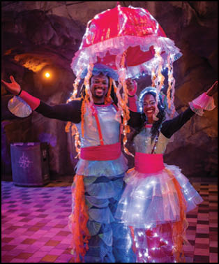 Two people dressed in costumes with lights on them. Description generated by AI