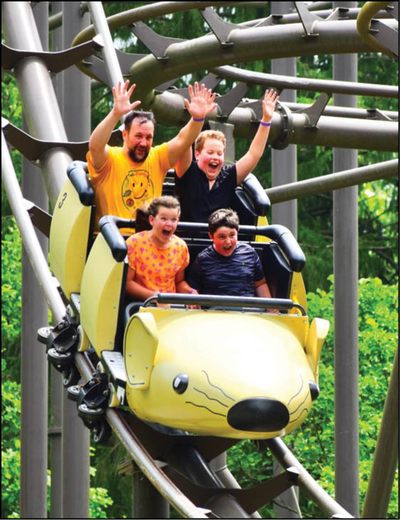 A yellow and black carousel with a group of people riding it. Description generated by AI