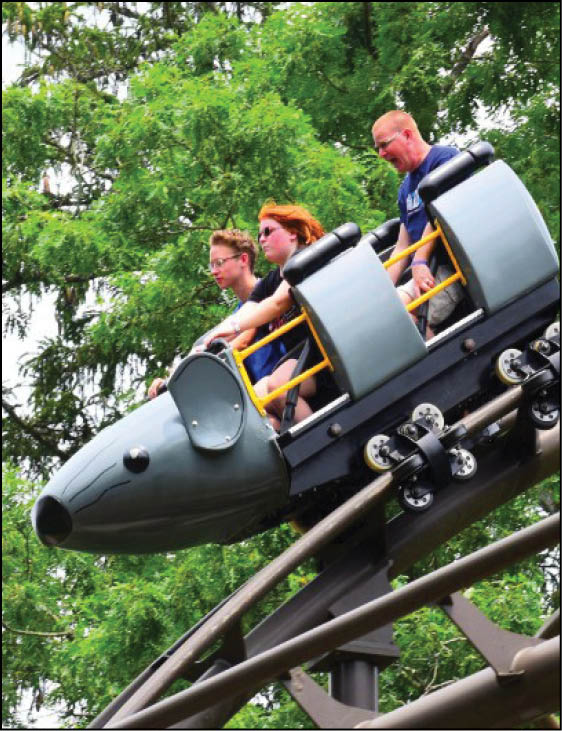 A roller coaster with three people riding it. Description generated by AI