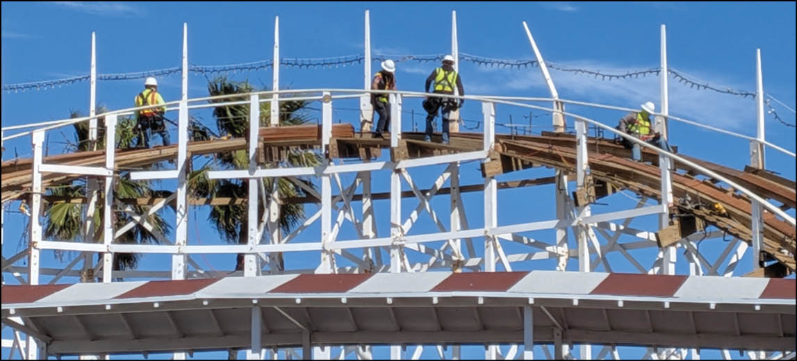 A group of men are working on a roller coaster. Description generated by AI