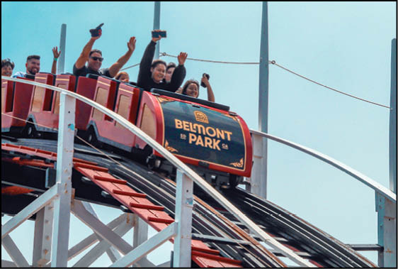A roller coaster with people riding it. Description generated by AI