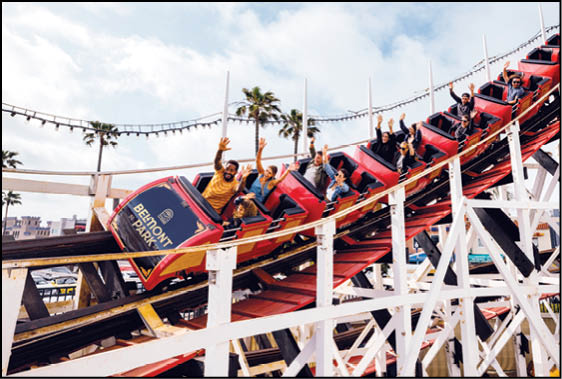 A roller coaster with people riding on it. Description generated by AI