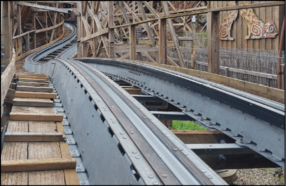 A wooden roller coaster with a metal track. Description generated by AI