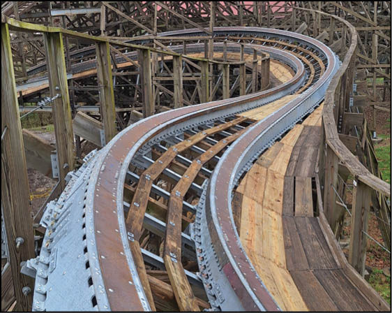 A wooden roller coaster with a metal track. Description generated by AI