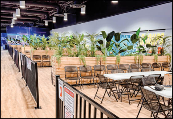 A black metal fence in front of a row of chairs. Description generated by AI