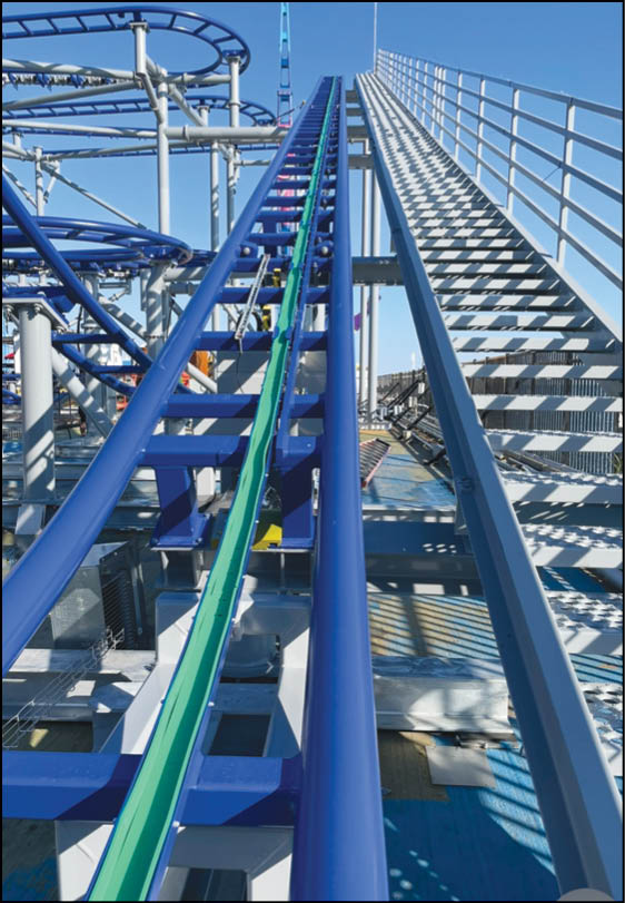 A blue and purple roller coaster on a track. Description generated by AI