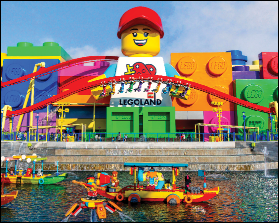 A large Lego statue is in front of a building. Description generated by AI