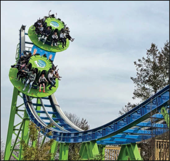 A green and blue roller coaster with a yellow center. Description generated by AI
