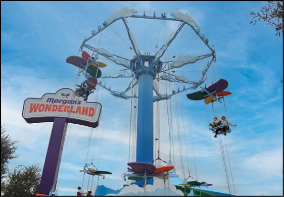 A large blue and white Ferris wheel with a red sign that says Wonderland. Description generated by AI