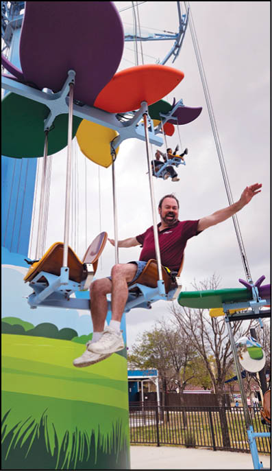 A man is swinging on a swing ride. Description generated by AI