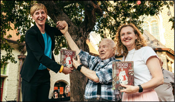 A woman is holding a book in her hand. Description generated by AI