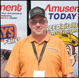 A man wearing an orange shirt and a badge. Description generated by AI