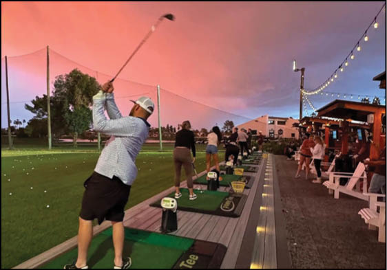 A man is swinging a golf club at a golf ball on a course. Description generated by AI