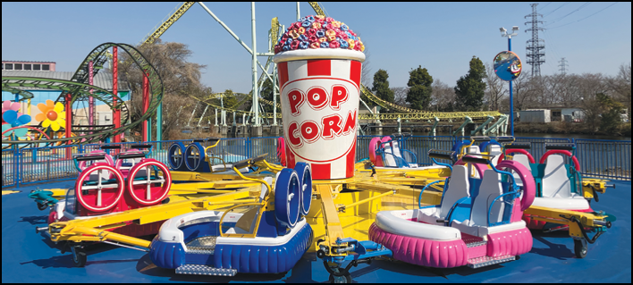 A large yellow and blue popcorn machine with a red and blue seat. Description generated by AI