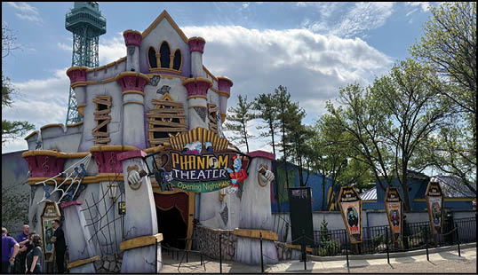 A large building with a clock tower and a sign that says “Phantasmagoria". Description generated by AI