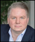 A man wearing a blue jacket and white shirt. Description generated by AI