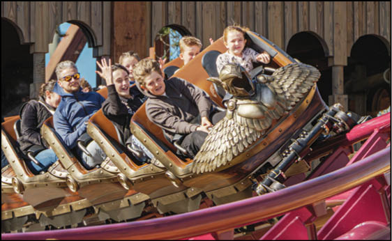 A group of people riding a roller coaster. Description generated by AI