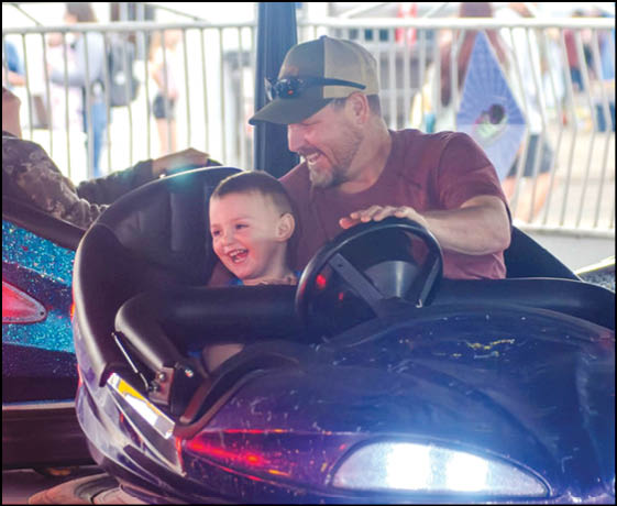 A man and a boy are riding a carousel. Description generated by AI