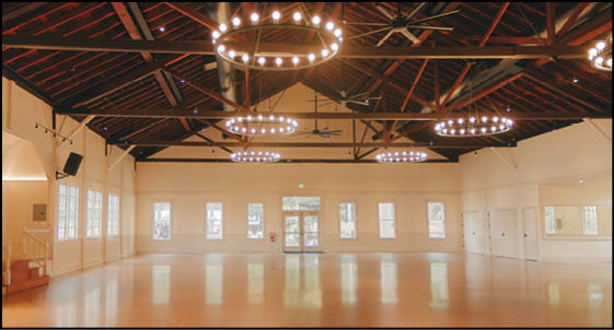 A large room with a high ceiling and a fan. Description generated by AI