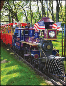 A train with a red, white, and blue flag on the front. Description generated by AI