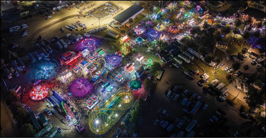 A carnival with lots of lights and rides. Description generated by AI