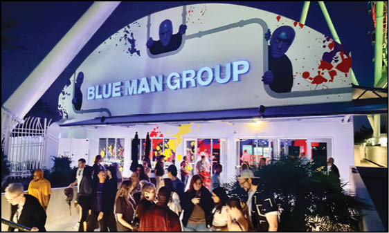 A group of people standing outside a building at night. Description generated by AI