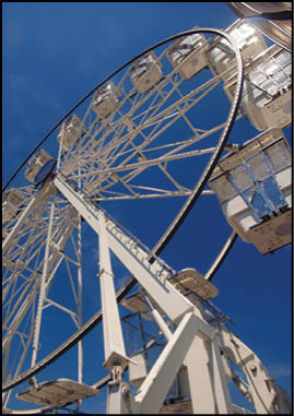 A large carnival ride with a white and black color scheme. Description generated by AI