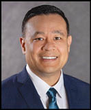 A man wearing a blue suit and a blue tie. Description generated by AI