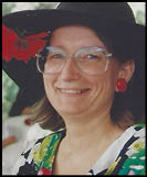 A woman wearing a hat and glasses. Description generated by AI
