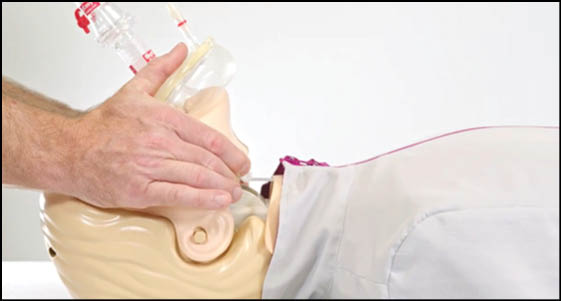 A man is putting a tube into a mannequin's head. Description generated by AI