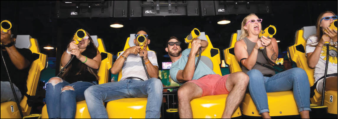 A group of people are sitting in a yellow ride at an amusement park. Description generated by AI