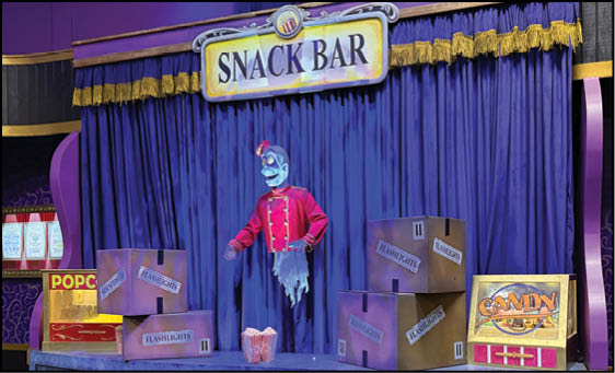 A purple and gold stage with a mannequin in a red and black outfit. Description generated by AI