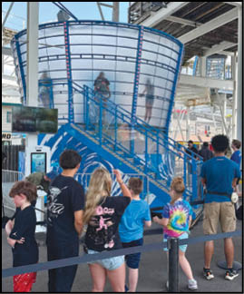A group of people are standing in front of a blue and white structure. Description generated by AI