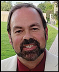A man wearing a blue jacket and white shirt. Description generated by AI