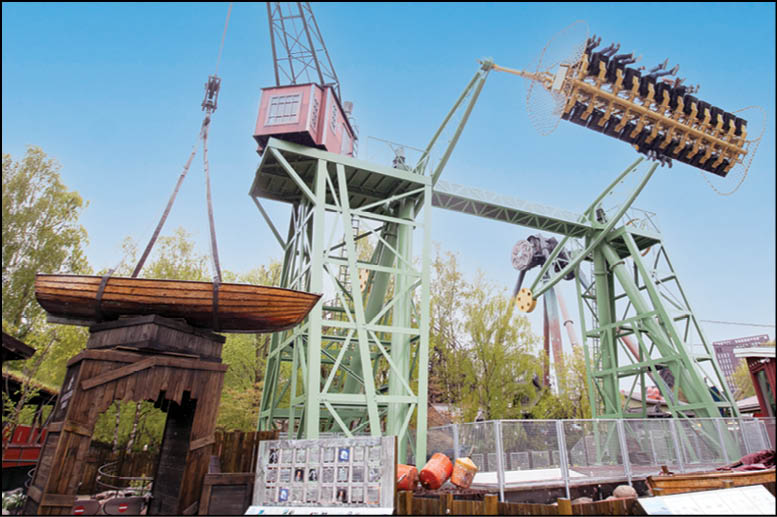 A large green crane with a red box on top. Description generated by AI