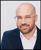 A man wearing a white shirt and black jacket. Description generated by AI