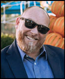 A man wearing a white shirt and black jacket. Description generated by AI