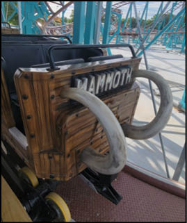 A green and blue roller coaster with a yellow center. Description generated by AI