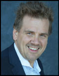 A man wearing a blue jacket and white shirt. Description generated by AI