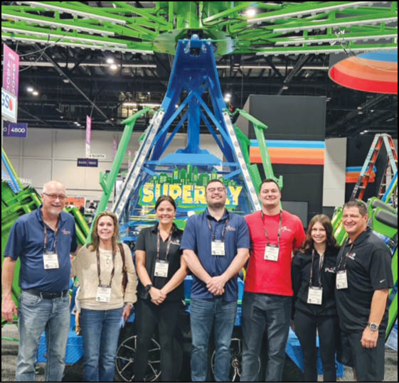 A group of people are sitting in a yellow ride at an amusement park. Description generated by AI