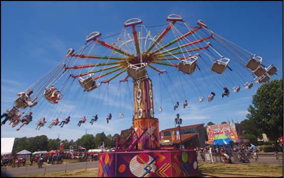A carnival with lots of lights and rides. Description generated by AI